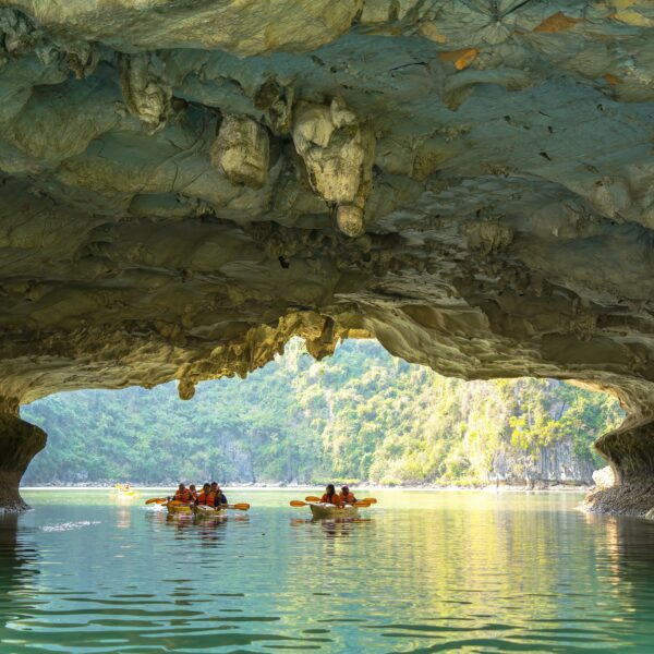 Tourists kayaking among limestone cliffs in Ha Long Bay